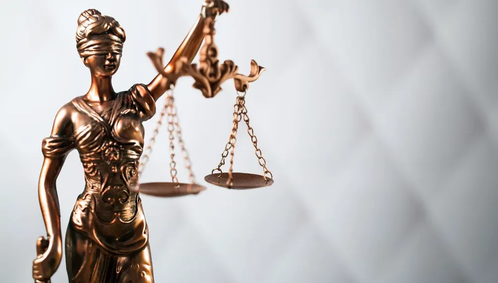Figura da justiça segurando a balança, em fundo claro